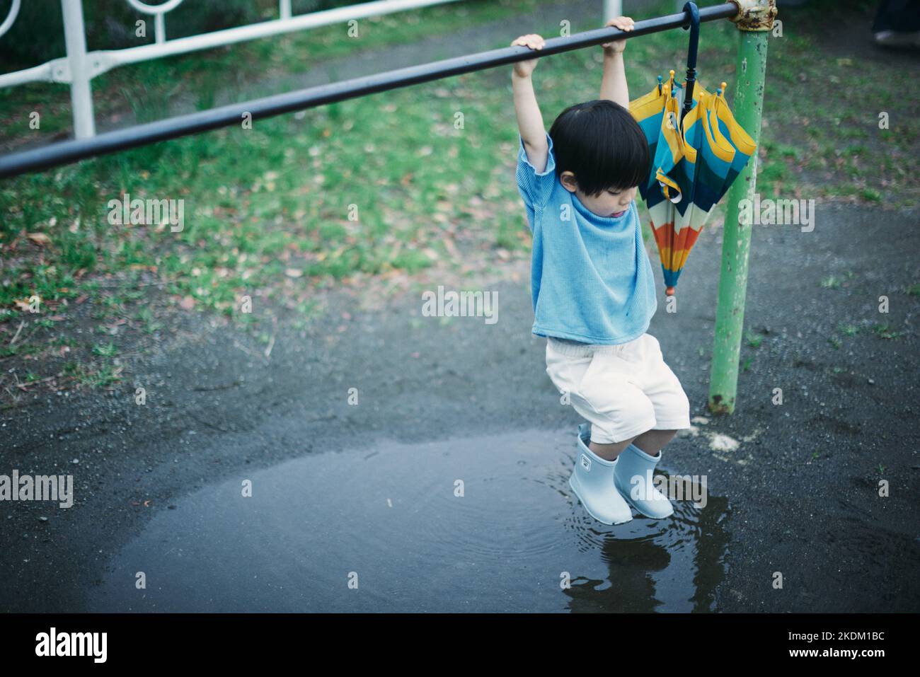 Enfant japonais jouant dehors le jour des pluies Banque D'Images