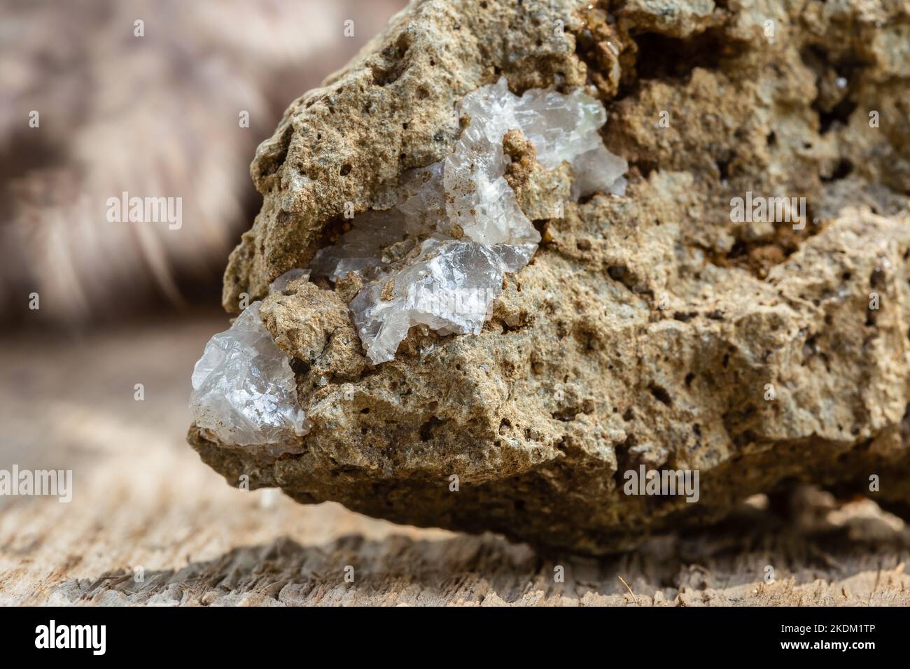 Photo macro de cristal de quartz clair sur pierre brute sur fond en bois Banque D'Images