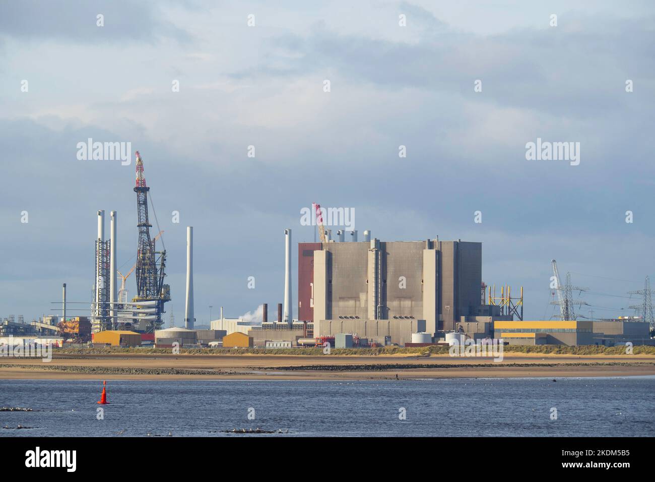 Grue à l'installation de recyclage située à côté de la centrale nucléaire de Hartlepool, chargeant les pales de grandes éoliennes sur un navire d'installation Banque D'Images