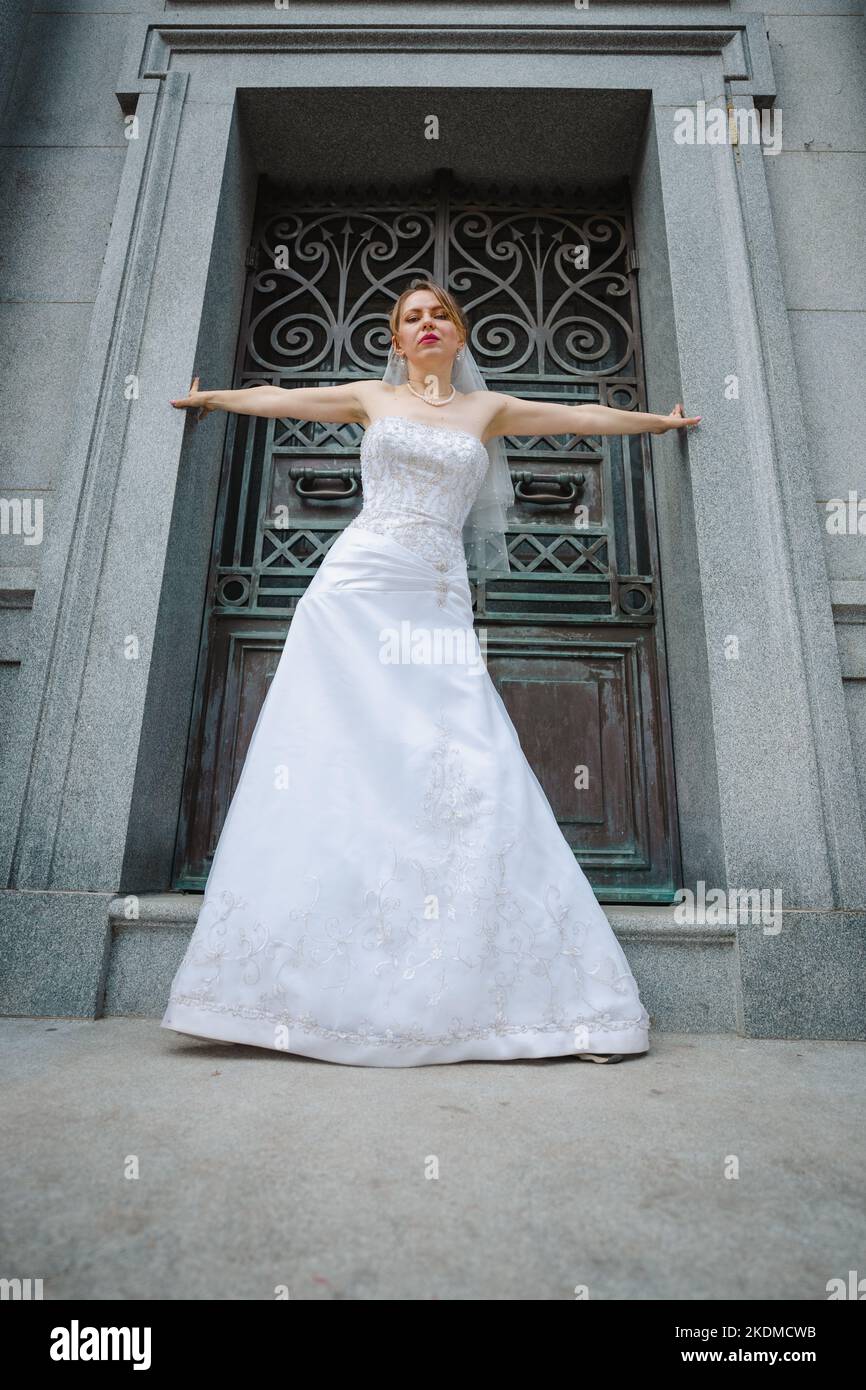 Mariée avec attitude debout devant un bâtiment de granit Banque D'Images