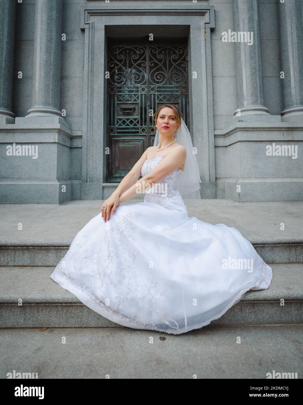 Mariée avec attitude debout devant un bâtiment de granit Banque D'Images