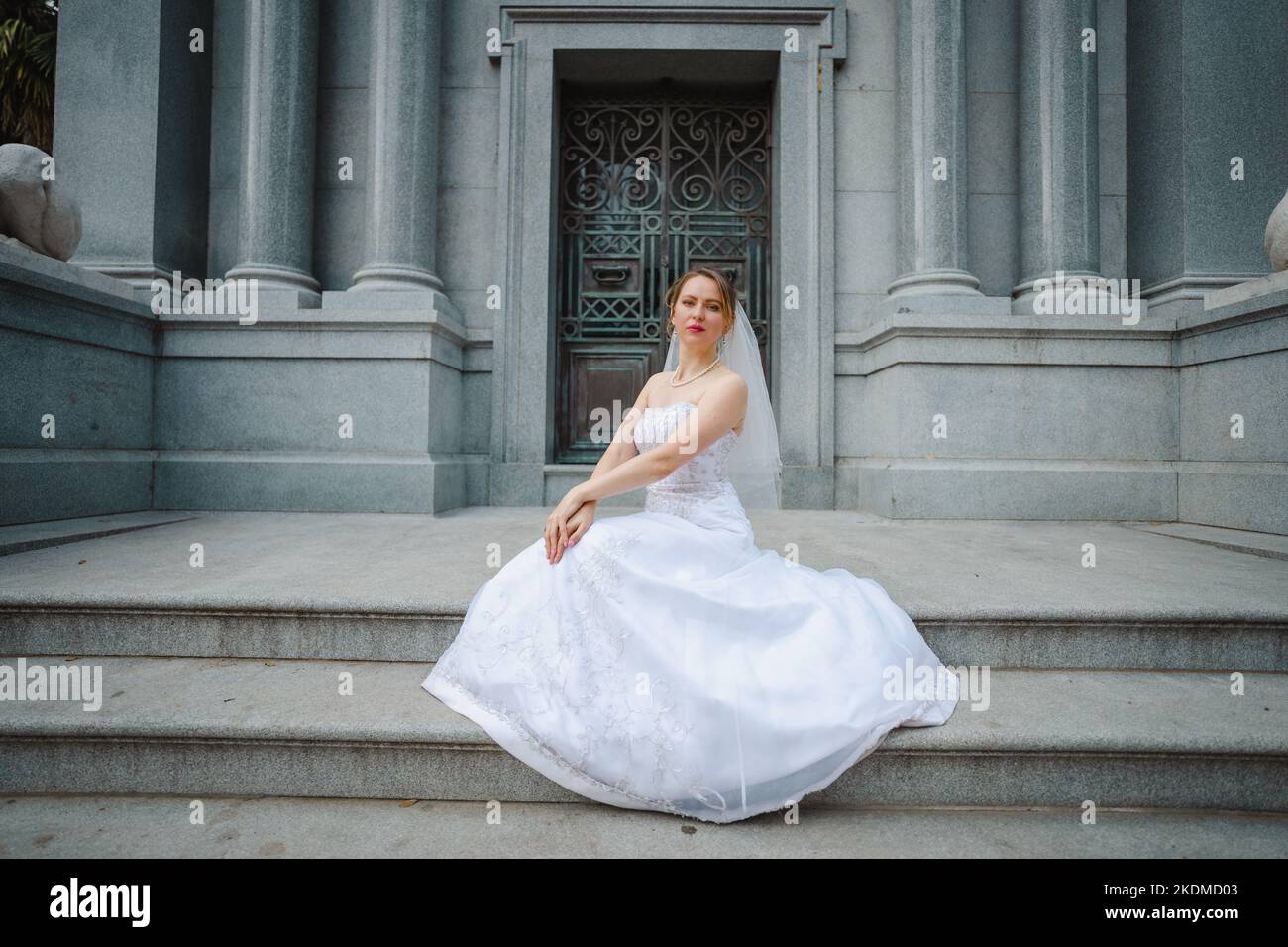 Mariée avec attitude debout devant un bâtiment de granit Banque D'Images