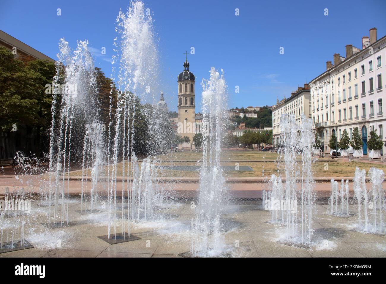 Une fontaine moderne avec vue sur l'ancienne Tour Bell de l'Hôpital de la Charité à la place Bellecour à Lyon. Banque D'Images