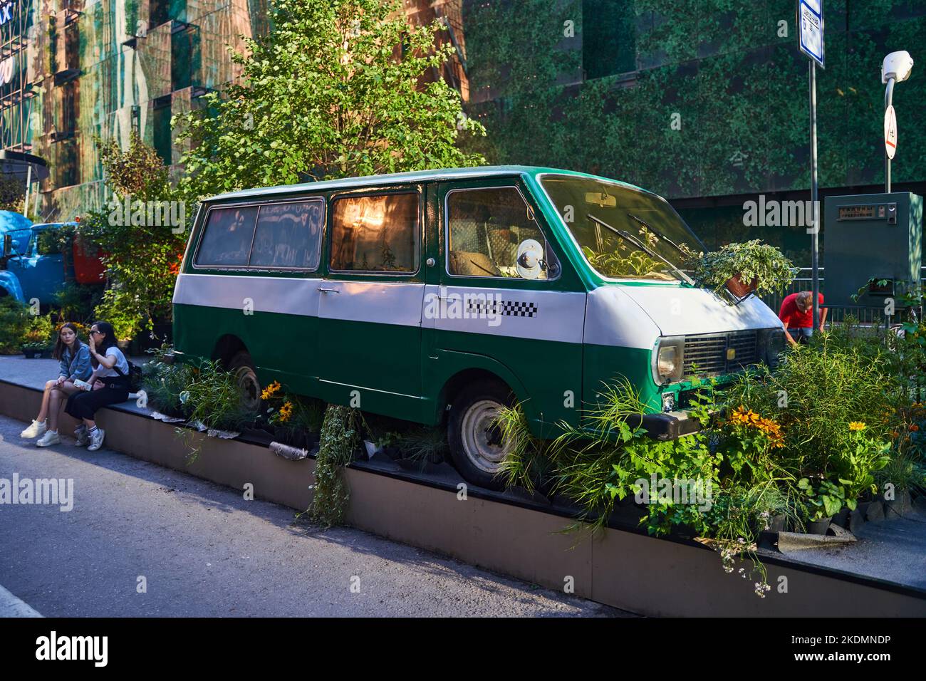 Moscou, Russie - 30.07.2022: Un vieux camion de taxi vert et blanc se tenant au milieu des plantes et des fleurs Banque D'Images