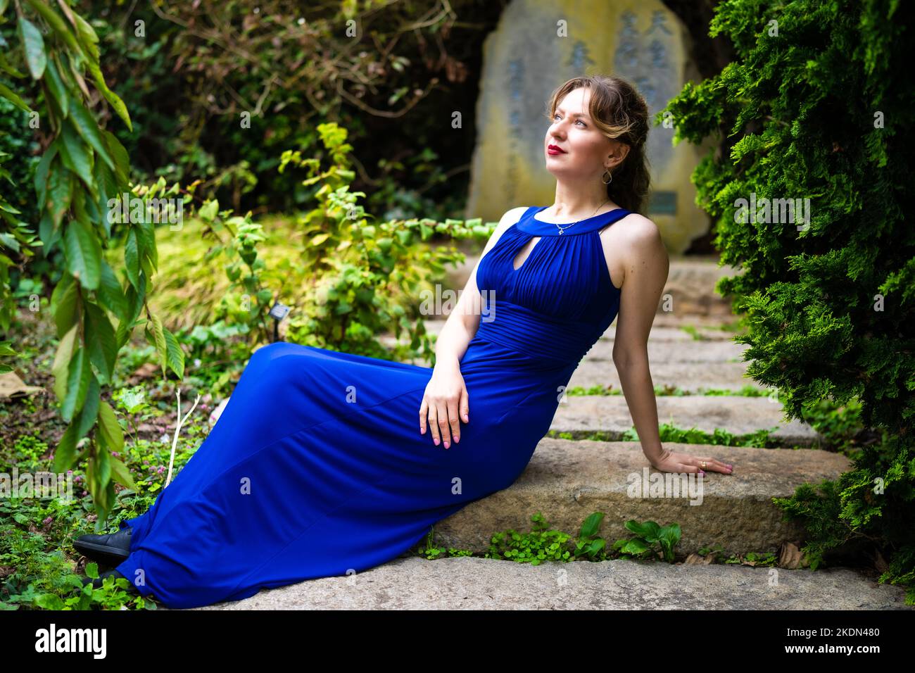 Femme portant un Blue Gown visitant un jardin botanique Banque D'Images
