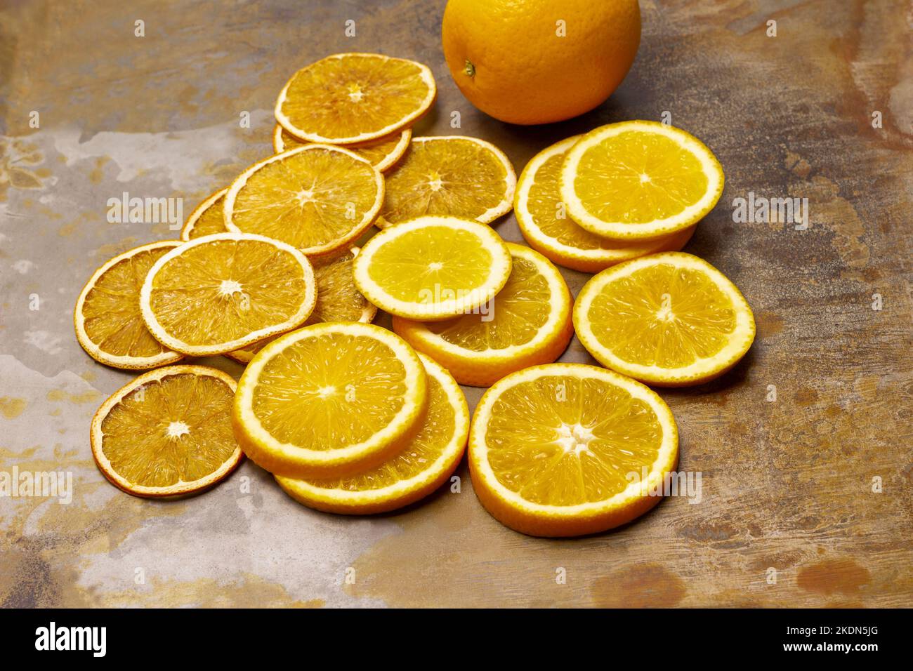 Tranches d'orange sèches et tranches d'orange fraîches. Orange frais entier. Vue de dessus. Arrière-plan en métal rouillé. Banque D'Images