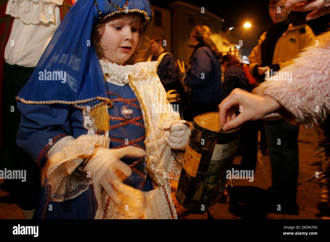 Mettre de l'argent dans la boîte de collecte de la Bonfire Society d'un enfant. Tout l'argent recueilli dans la rue est donné à une œuvre de charité. Les mères et les enfants Tudor passent devant le monument commémoratif de guerre après avoir déposé une couronne au monument commémoratif de guerre. La Borough Bonfire Society vêtue de costume Tudor ou de passeurs, de croix légères et de torches dans le cadre des processions flamboyantes des pompiers à travers les rues de Lewes sur 5 novembre, Guy Fawkes Night. Banque D'Images