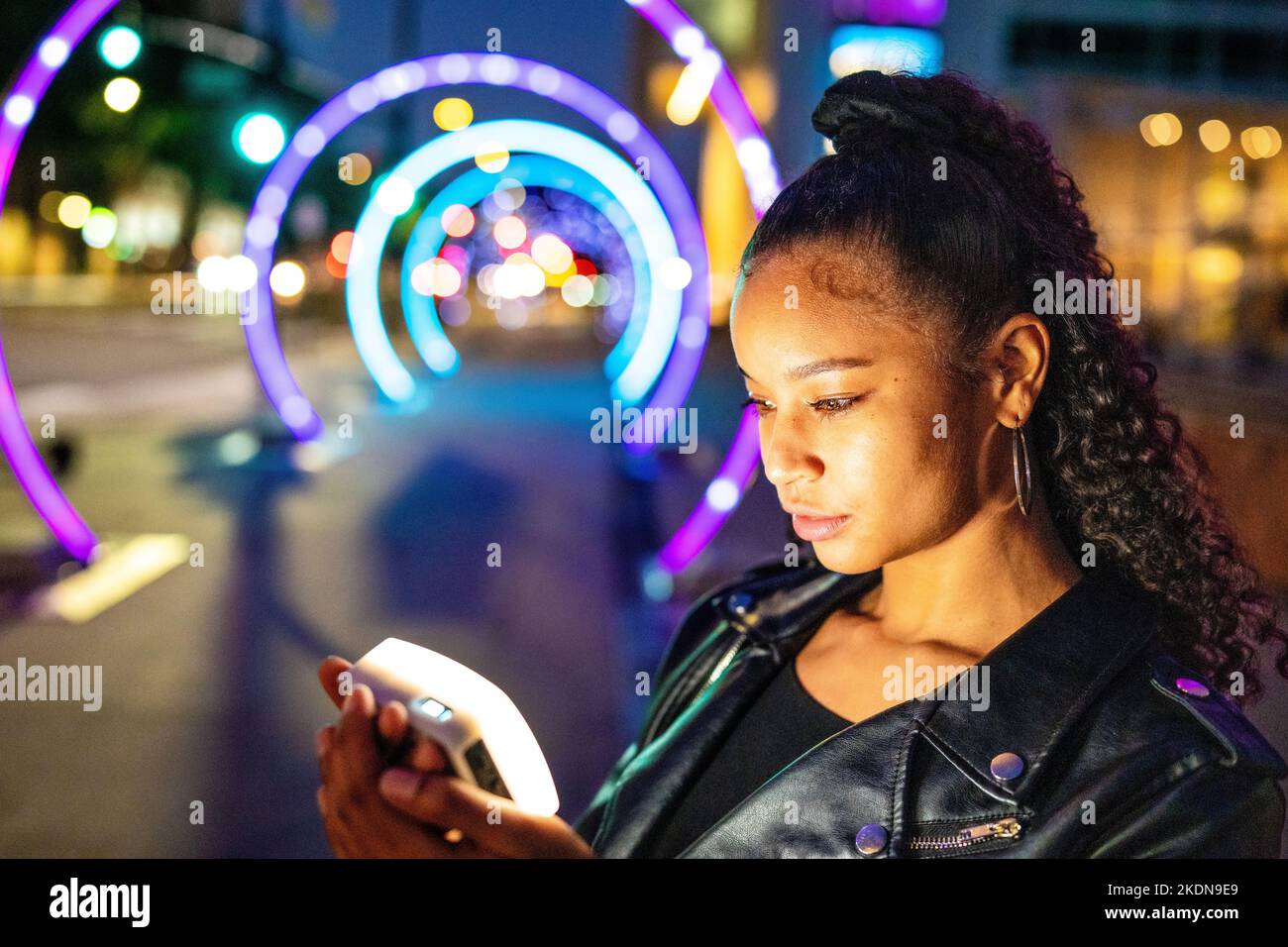 Jeune femme dans l'éclairage coloré à la passerelle Sonic à San Jose Banque D'Images
