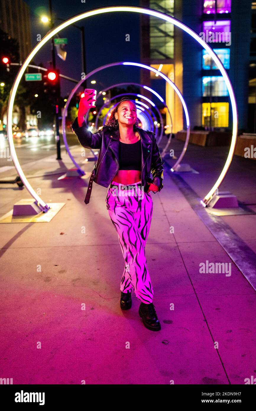 Jeune femme dans l'éclairage coloré à la passerelle Sonic à San Jose Banque D'Images