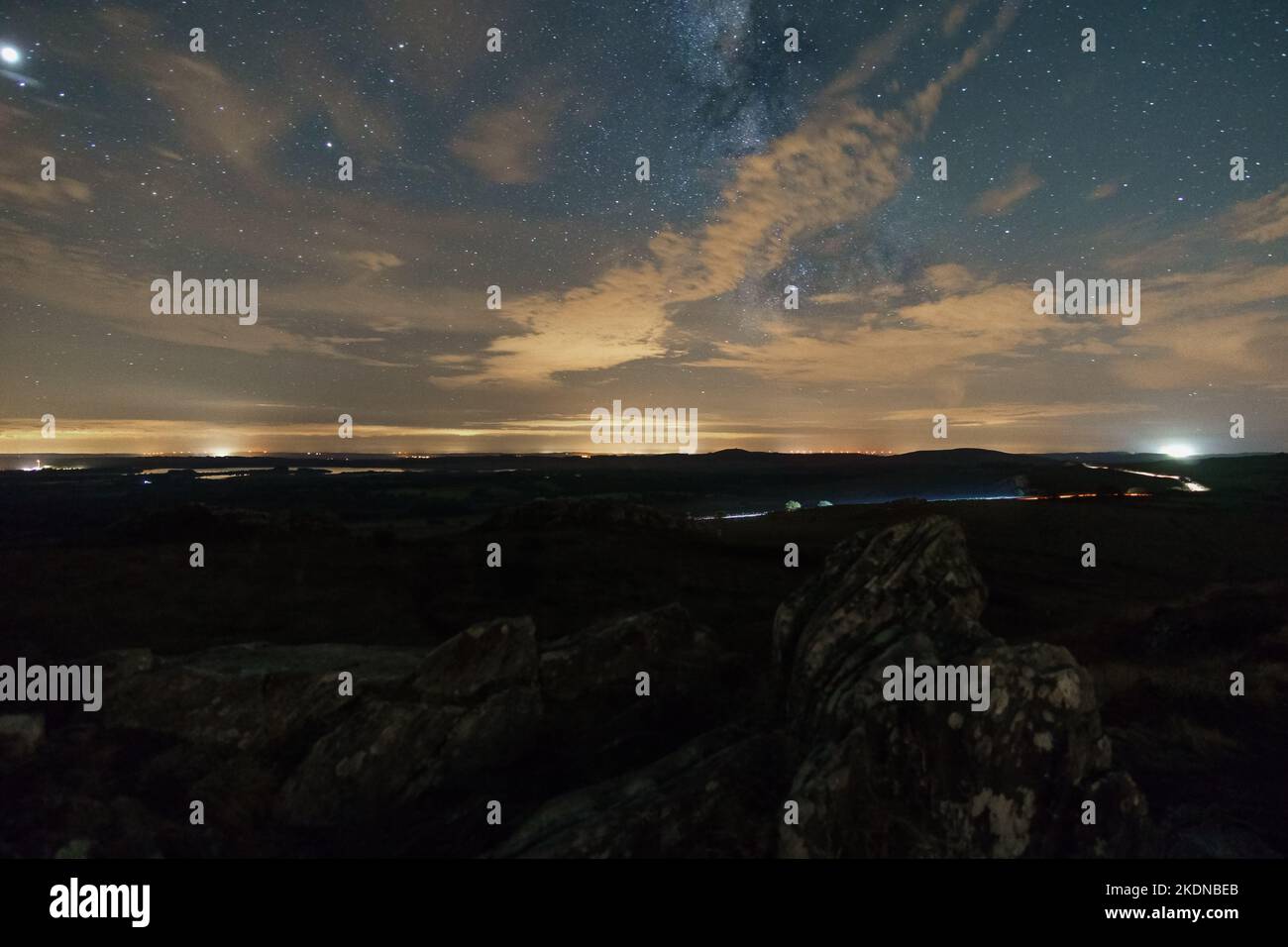 Paysage rocheux au sommet du Roc'h Trevezel la nuit avec des nuages qui couvrent légèrement la voie lactée, Parc naturel régional d'Armorique, Bretagne, France Banque D'Images