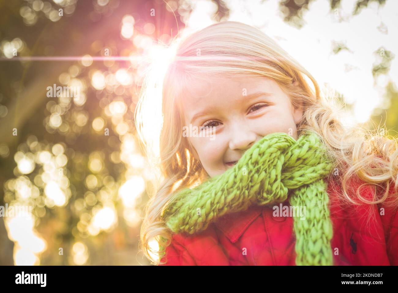 Petite fille portant un manteau d'hiver et une écharpe au parc. Banque D'Images