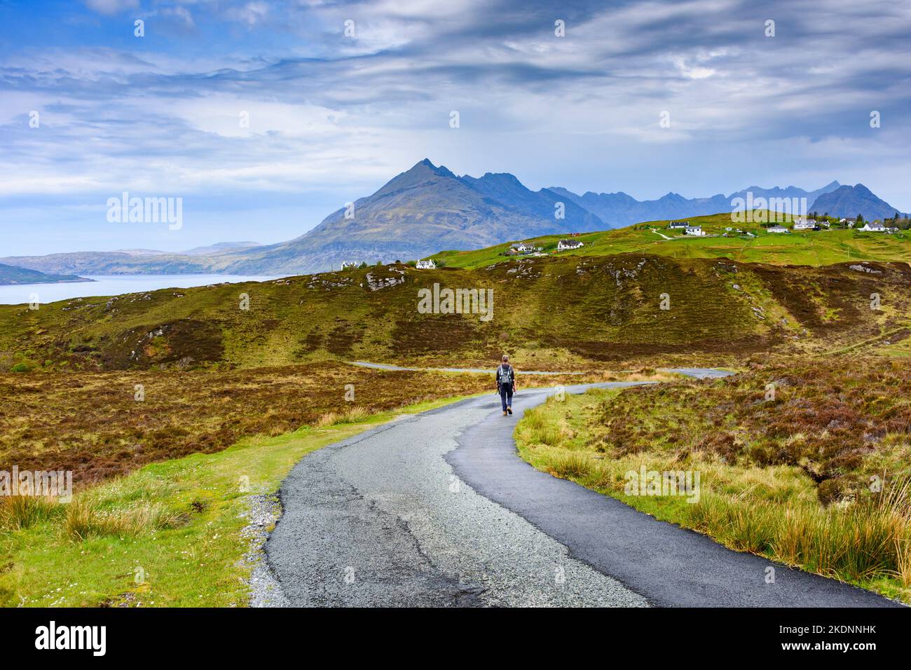 Un marcheur sur la route des moorland en direction d'Elgol, île de Skye, Écosse, Royaume-Uni. Les montagnes de Cuillin au loin. Banque D'Images