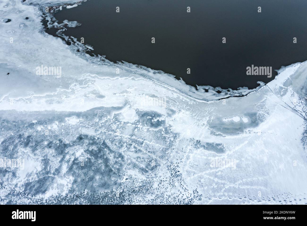 lakeshore. paysage hivernal avec structure de glace sur la surface de l'eau et rivage enneigé. vue aérienne. Banque D'Images