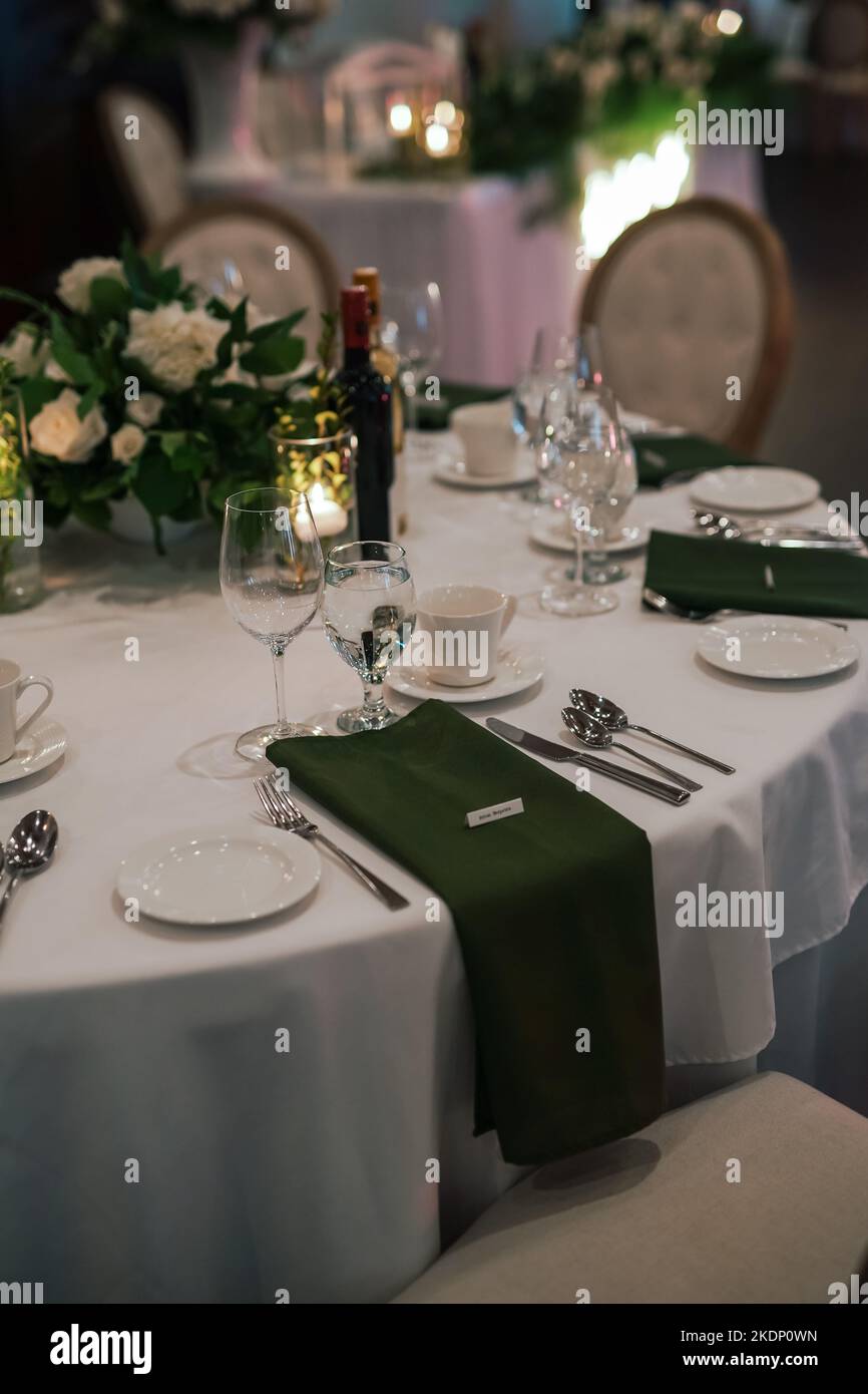 table de salle à manger linge de table blanc serviettes vert verres ustensiles Banque D'Images