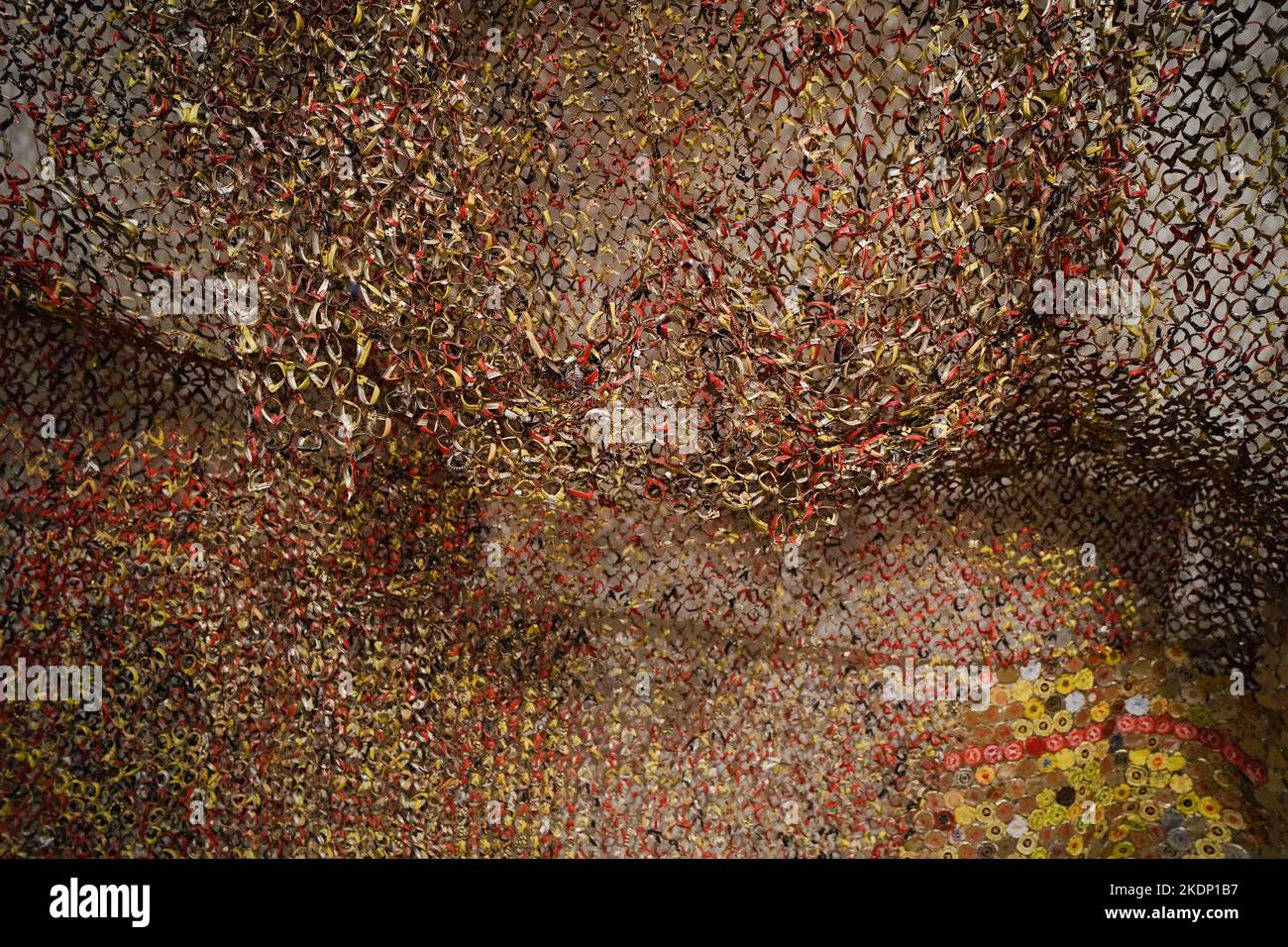 Grande tapisserie en métal faite avec des hauts de bouteille de liqueur jetés par l'artiste africain El Anatsui. Les dessus de bouteille sont des marchandises d'importation et ont un fort hist africain Banque D'Images
