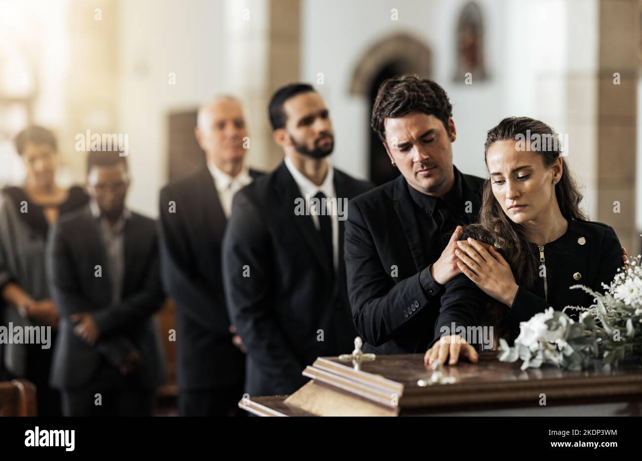 Mort, funérailles et famille touchant le cercueil dans une église, triste et malheureux tout en se rassemblant pour dire adieu. Casket de service d'église et homme triste et femme Banque D'Images