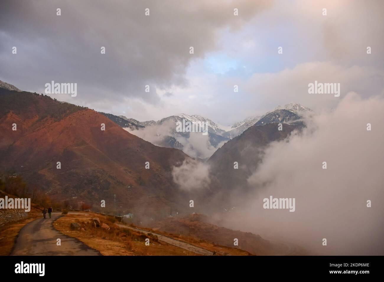 Srinagar, Inde. 07th novembre 2022. Les gens marchent à travers une route tandis que les nuages engloutissent les montagnes pendant une journée d'automne froide à la périphérie de Srinagar. Les pluies ont continué à frapiller les plaines tandis que les tronçons supérieurs ont reçu des chutes de neige alors que l'homme météorologique avait prédit un temps plus humide à Jammu-et-Cachemire jusqu'à 11 novembre. (Photo de Saqib Majeed/SOPA Images/Sipa USA) crédit: SIPA USA/Alay Live News Banque D'Images