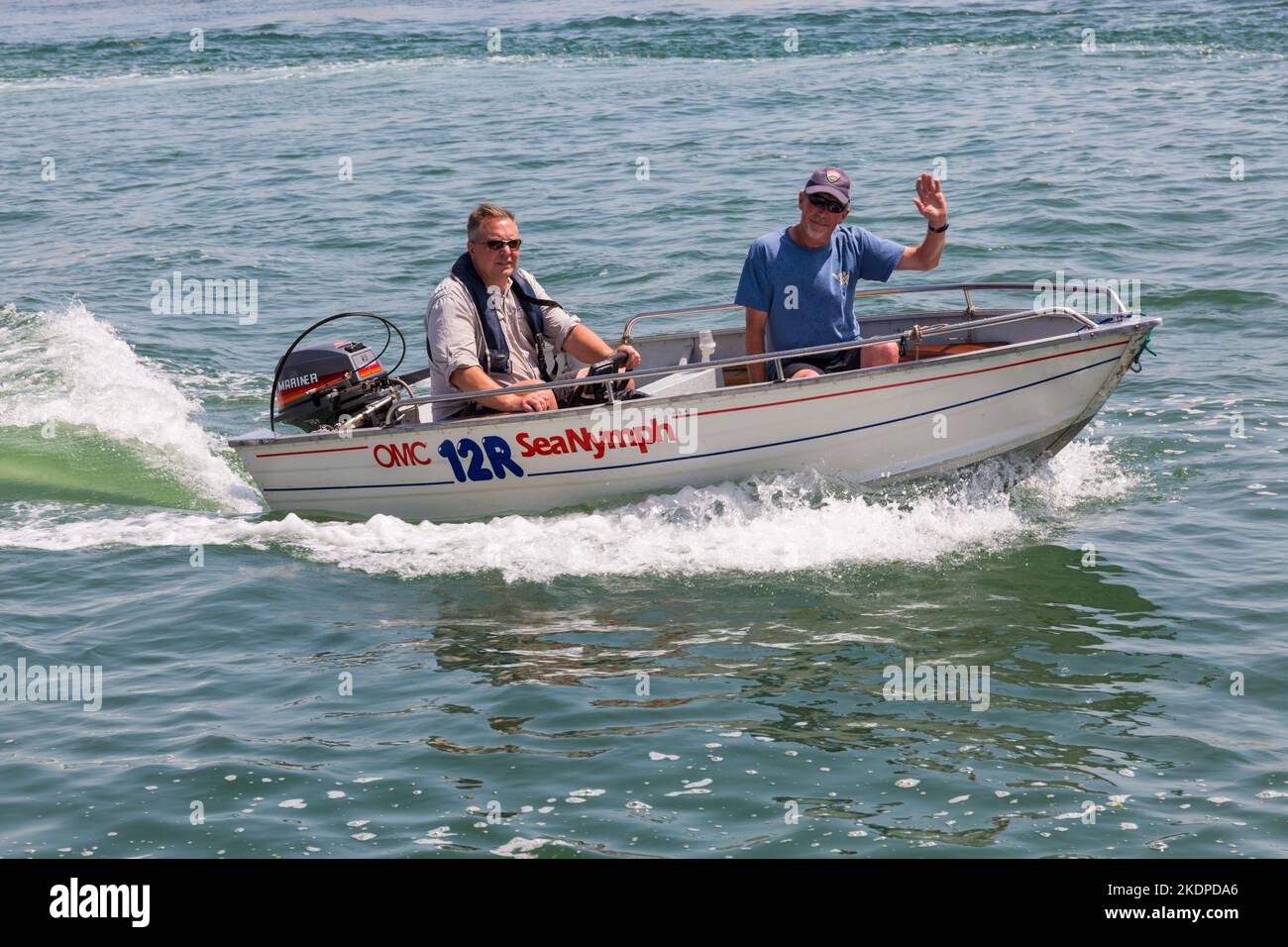 Deux hommes en OMC 12R Sea Nymph bateau se rendre à l'entrée du port de Christchurch, connu sous le nom de The Run, Mudeford, Dorset UK en juin Banque D'Images