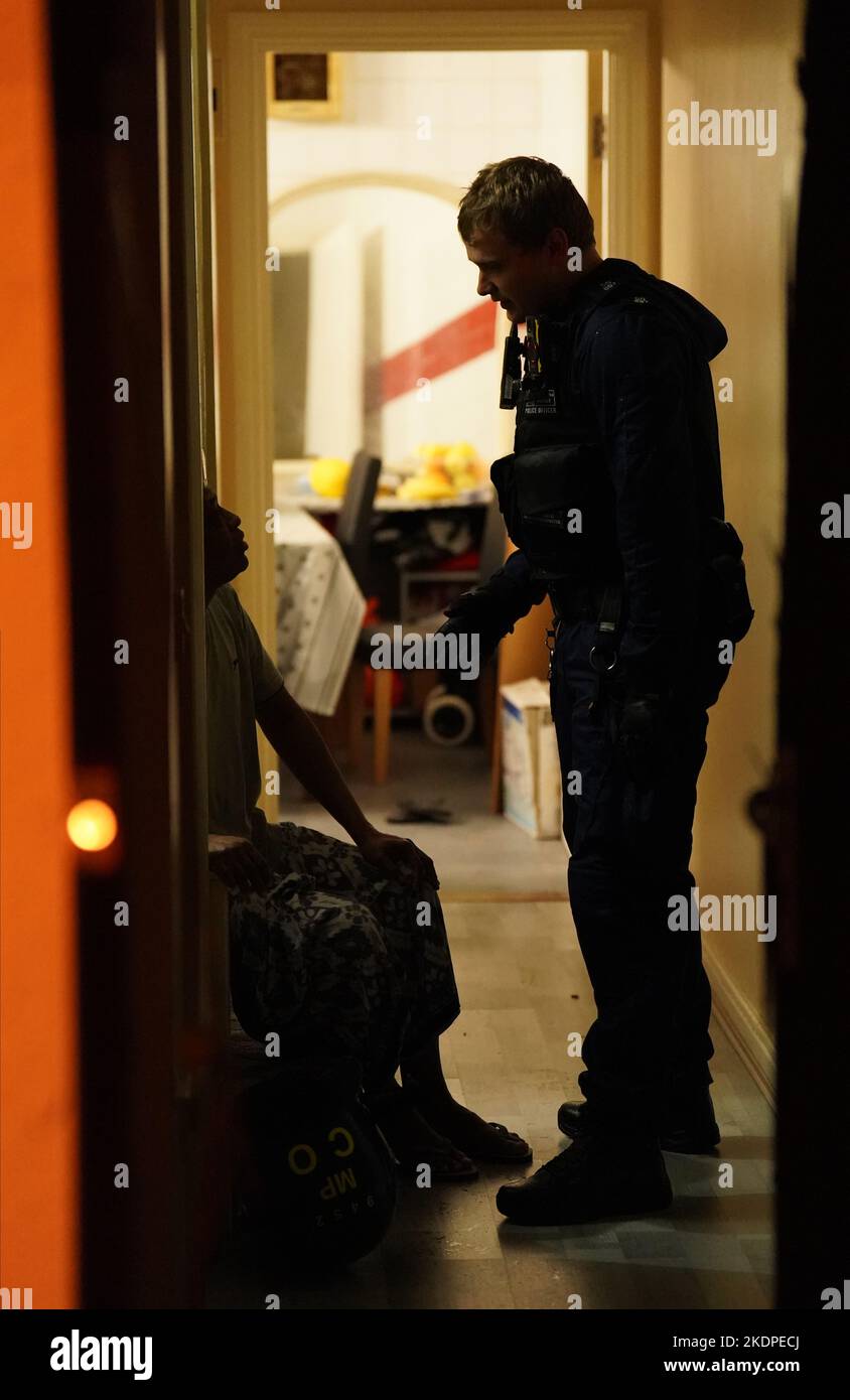 Des officiers de la police métropolitaine parlent à un résident lors du raid d'une maison à Islington, dans le nord de Londres, dans le cadre d'une répression contre la drogue et la violence associée dans la capitale. S'appuyant sur le succès de la réponse de met County Lines, l'opération Yamata a été lancée en avril de cette année et se concentre sur l'écrasement des lignes de médicaments de classe A à l'intérieur de Londres. Date de la photo: Mardi 8 novembre 2022. Banque D'Images