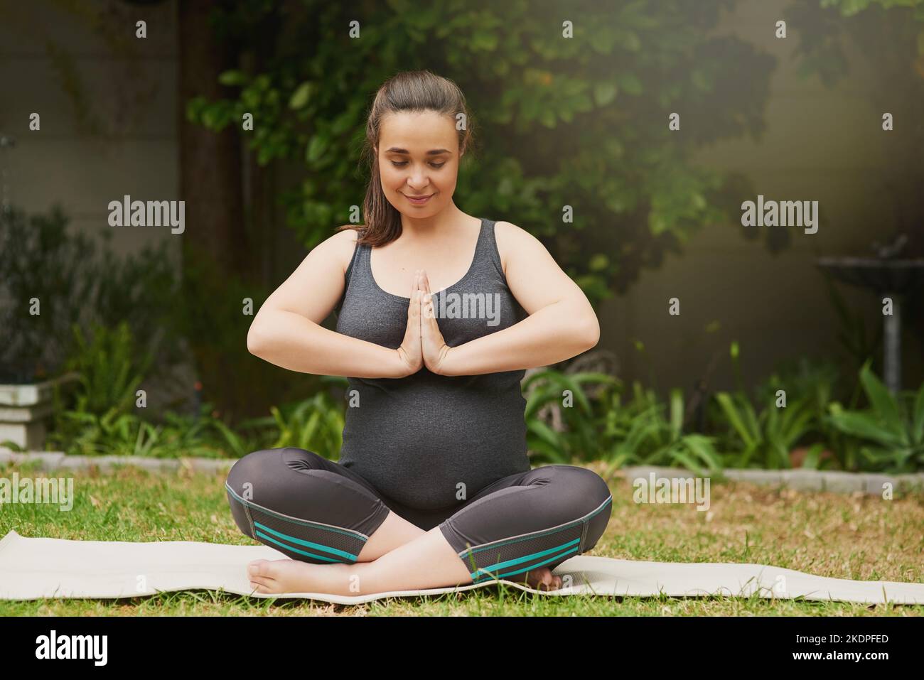 Trouver l'équilibre est bon pour le bébé. Prise de vue en longueur d'une jeune femme enceinte attirante méditant à l'extérieur. Banque D'Images
