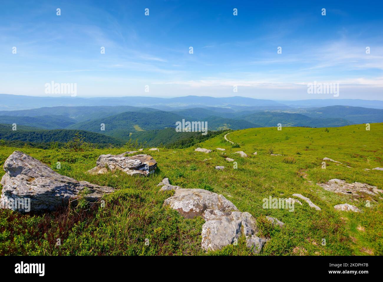 paysage alpin des montagnes carpathes. pierres sur les collines herbeuses. temps ensoleillé avec nuages au-dessus de la crête lointaine Banque D'Images