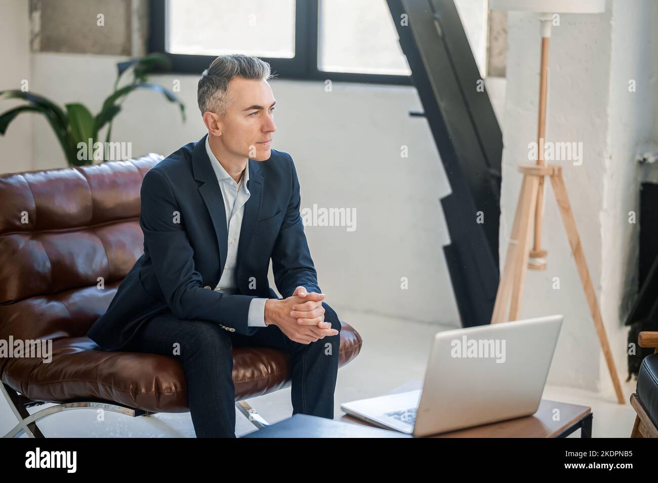 Homme d'affaires en costume assis dans un bureau Banque D'Images