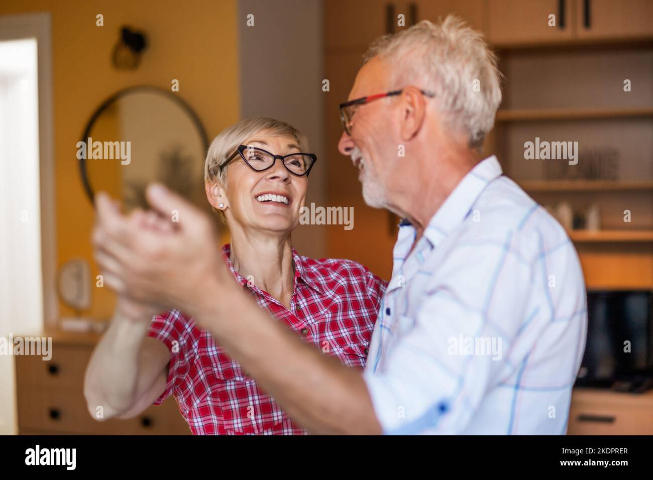 Un couple senior heureux danse à la maison. Les aînés ont passé un bon moment ensemble. Banque D'Images
