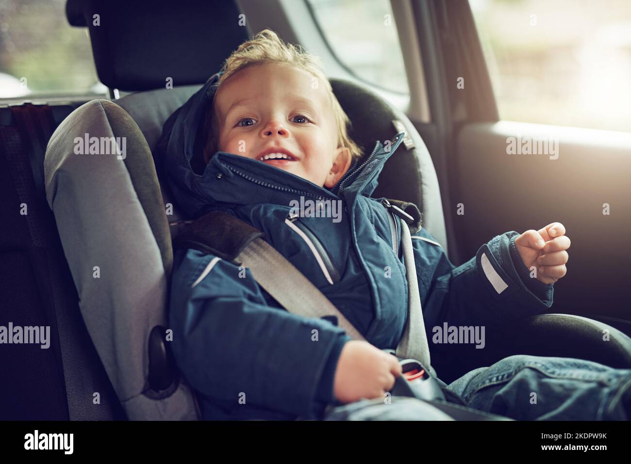 Tous les éléments sont attachés pour un trajet sur route. Portrait d'un adorable petit garçon assis dans un siège d'auto. Banque D'Images