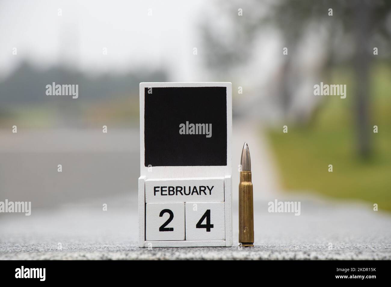 Calendrier en bois avec la date 24 février, le premier jour de la guerre en Ukraine et une balle se dresse sur la route de la ville, date historique, guerre 2022 Banque D'Images