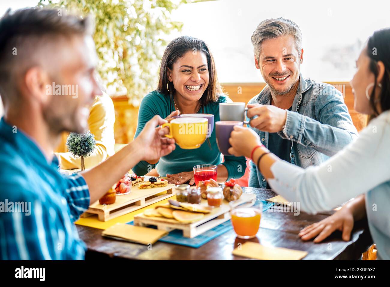 Groupe d'amis toaster tasses au café-bar sur le toit - des gens de la gamme d'âge mixte parler et s'amuser ensemble au restaurant cappuccino - style de vie conce Banque D'Images