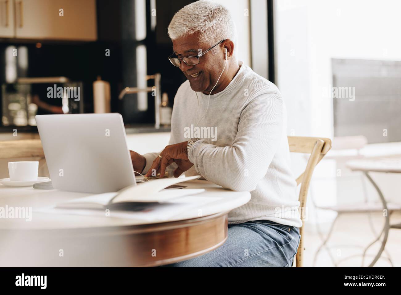Homme d'affaires joyeux assistant à une réunion virtuelle dans son bureau à domicile. Homme d'affaires mature ayant une visioconférence avec ses collègues pendant que wor Banque D'Images