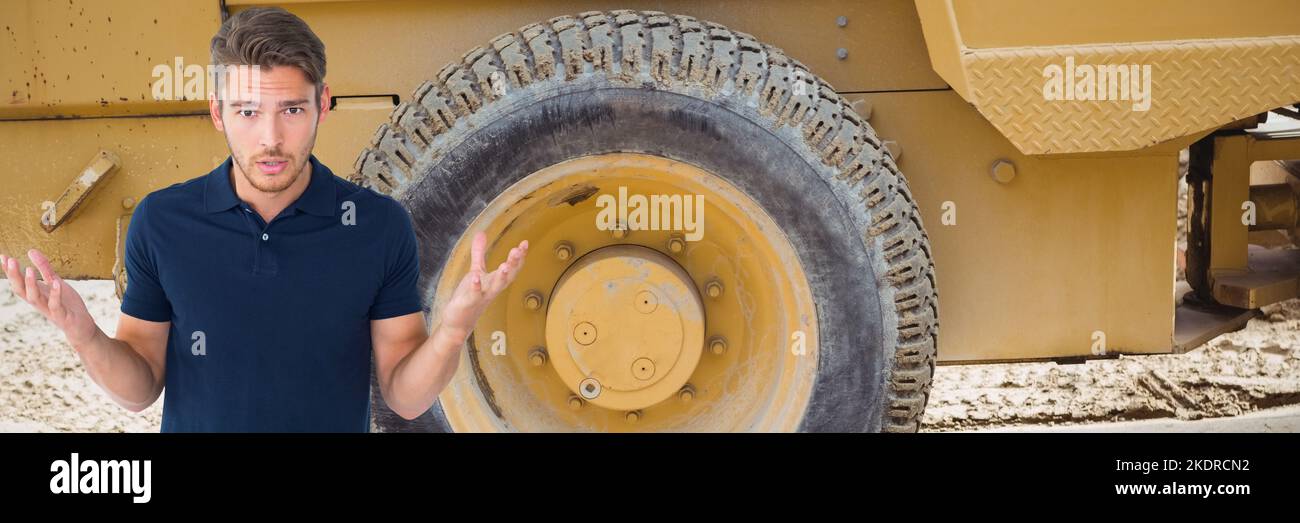 Portrait d'un jeune homme caucasien frustré haussant les épaules contre un véhicule de construction Banque D'Images