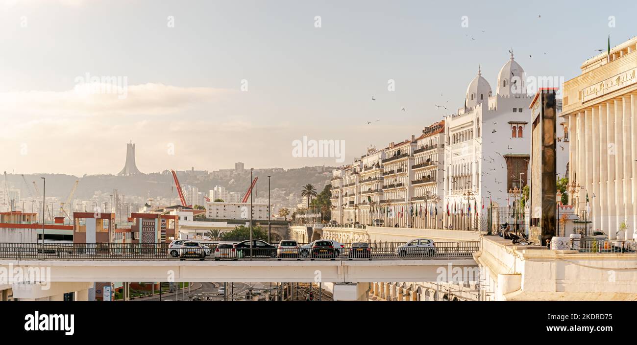 L'Assemblée nationale du peuple et le siège de la Wilaya avec des oiseaux volants, des voitures garées et des drapeaux arabes et le monument commémoratif du Martyr. Banque D'Images