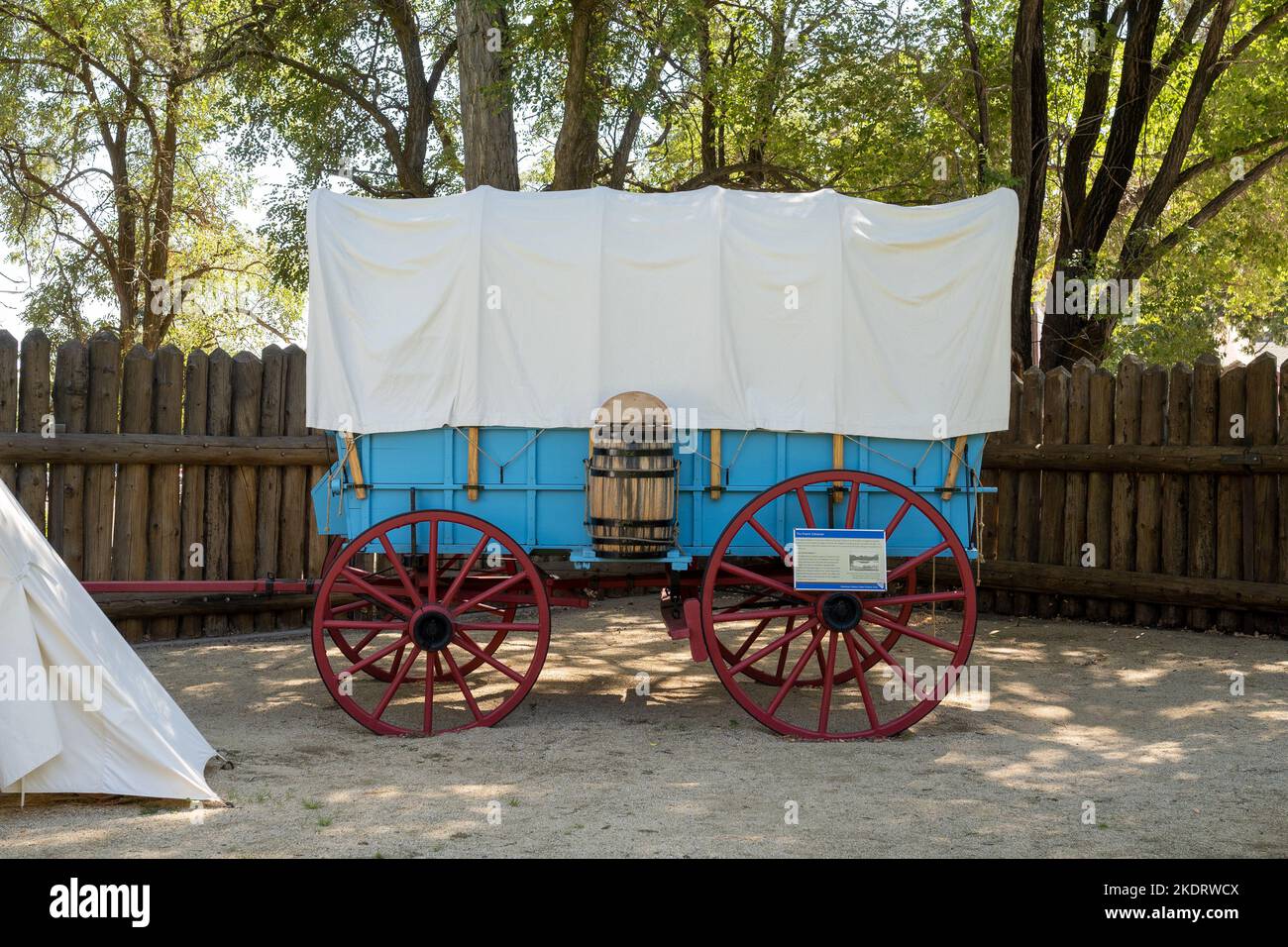 Gênes, Nevada, États-Unis. 2022-09-17. Tente de toile de nuit à côté d'un wagon bleu de Prairie Schooner avec roues rouges au parc historique de Mormon Station. Banque D'Images