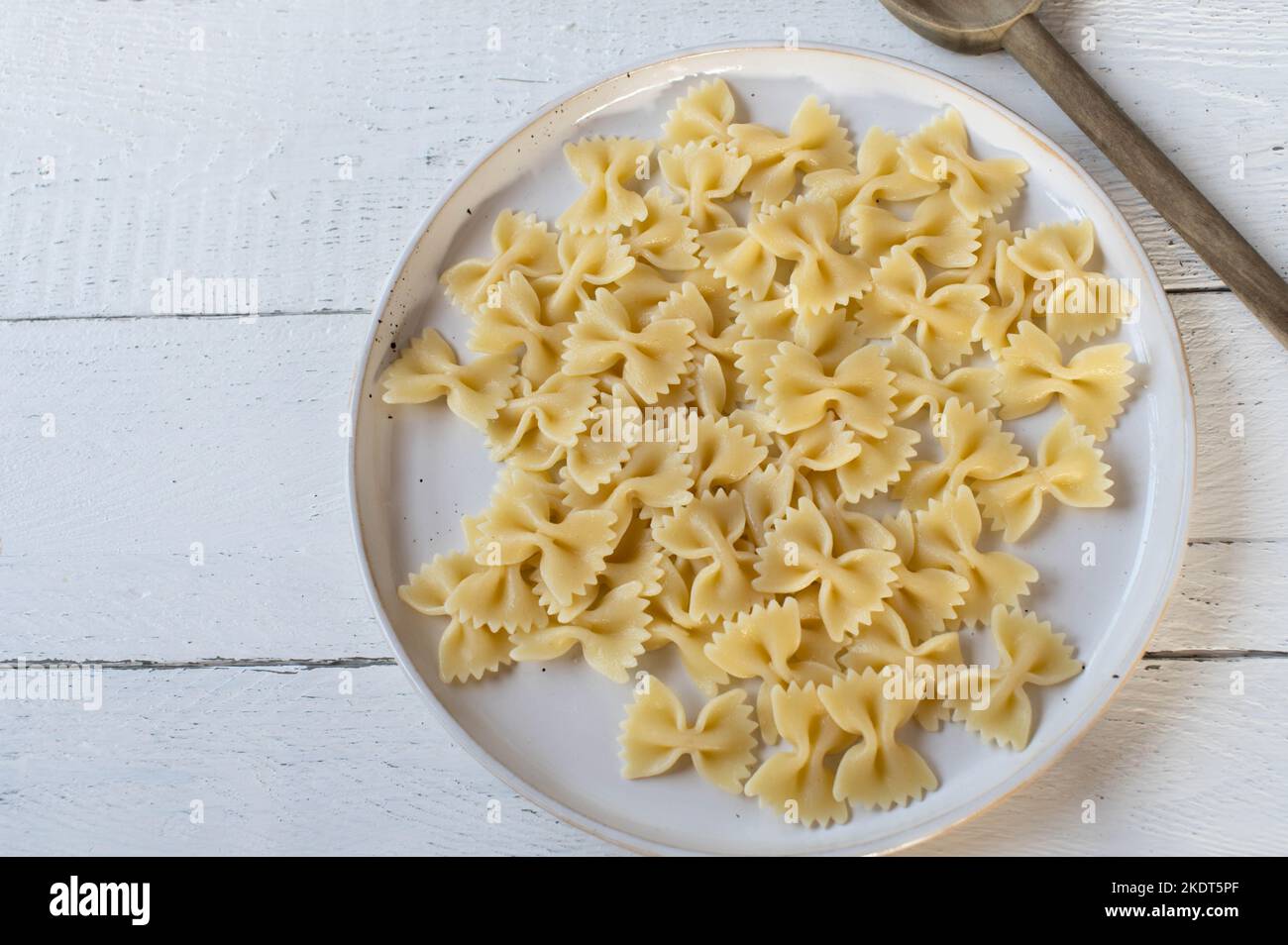 Pâtes farfalle cuites ou noeud sur une assiette sur fond blanc Banque D'Images