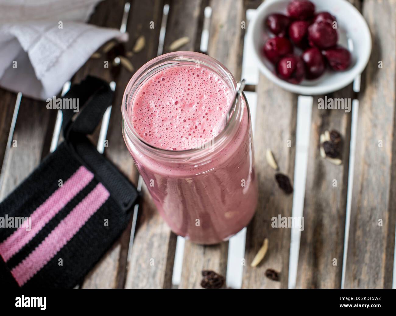 Avant l'entraînement, secouez les protéines avec du lactosérum, des cerises acides pour les glucides complexes, les amandes et les raisins secs Banque D'Images