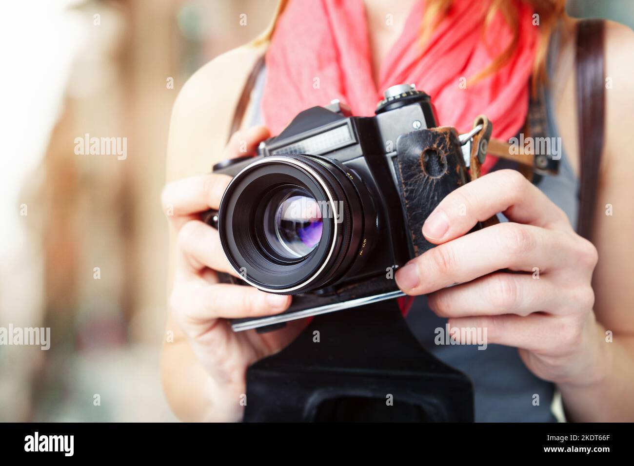 Femme photographe tenant un ancien appareil photo 35mm. Banque D'Images