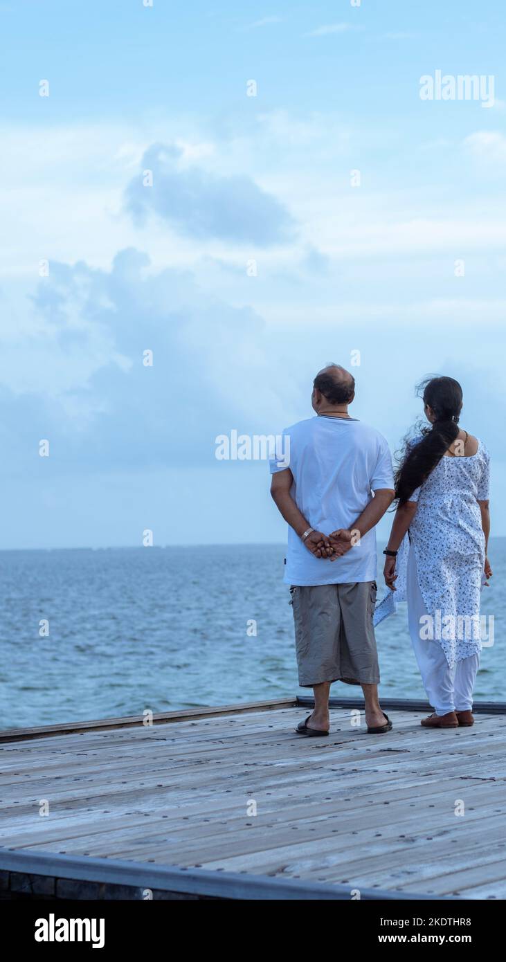 Une photo de deux couples se tenant au bord d'une plate-forme et regardant la belle mer bleue et le ciel Banque D'Images
