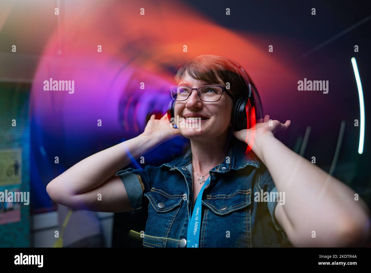 une femme avec un casque dans une discothèque silencieuse dans une bibliothèque Banque D'Images