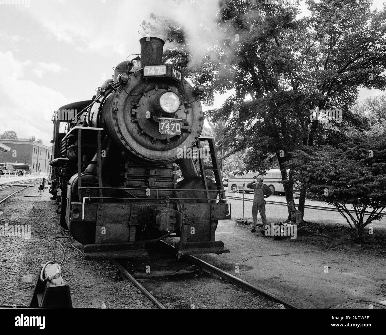 Un mécanicien boit une bouteille de Coke en aloing à côté d'une locomotive à vapeur d'époque à la gare de Conway Scenic Railroad à North Conway, dans le New Hampshire. L'im Banque D'Images