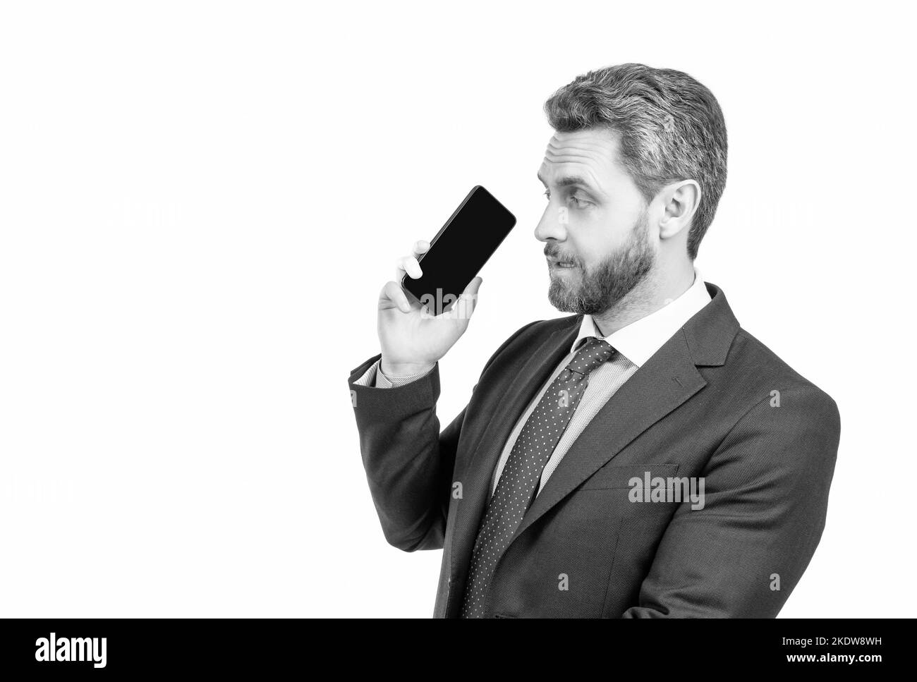 Un responsable professionnel sérieux en costume tient le téléphone portable isolé sur l'espace de copie blanc, smartphone Banque D'Images
