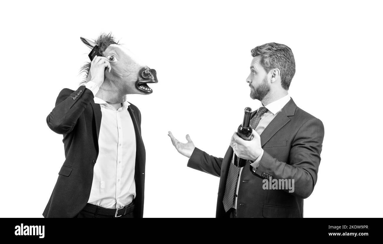 Communication d'entreprise. Homme portant une tête de cheval parler sur un téléphone portable. Communication d'entreprise. Un homme d'affaires saoul tient une bouteille de vin. Fête du personnel. Ce. De travail Banque D'Images