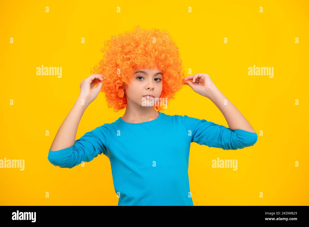 Belle adolescente dans perruque isolée sur jaune. Perruque clown amusante. Banque D'Images