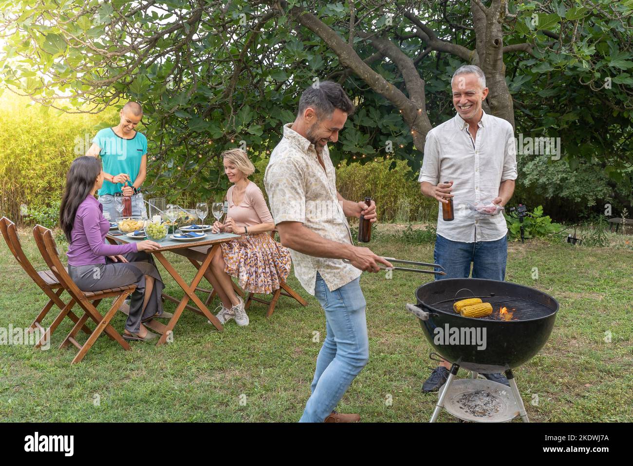 sourire heureux et rire ensemble groupe de personnes autour du barbecue. Concept de joie. Banque D'Images