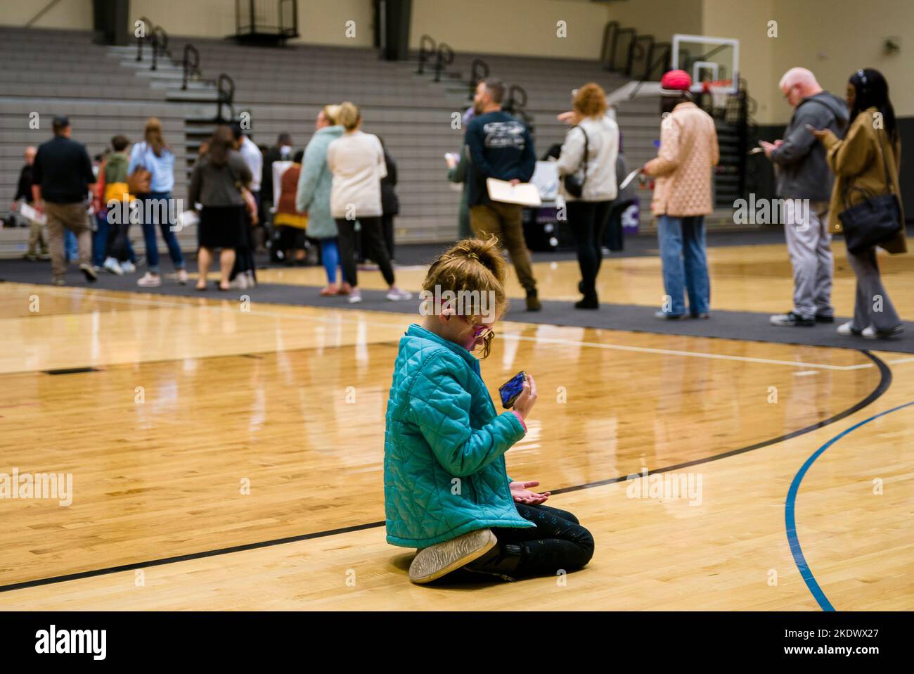 Columbus, Ohio, États-Unis. 8th novembre 2022. CORA LLOYD, 8 ans, regarde une vidéo YouTube sur son téléphone alors que sa mère Claire Lloyd attend en ligne au bureau de vote du Columbus Africentric Early College à Columbus, Ohio, le mardi 8 novembre 2022. (Credit image: © Jintak Han/ZUMA Press Wire) Credit: ZUMA Press, Inc./Alamy Live News Banque D'Images