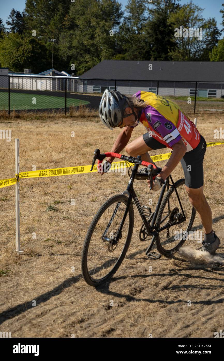 WA22614-00...WASHINGTON - Tom Kirkendall sautant de nouveau sur son vélo après avoir courez et bondissant à travers les barrières solides lors d'une course de cyclocross. Banque D'Images