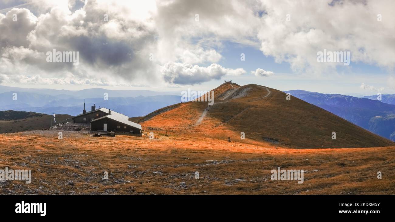 vue imprenable sur une maison et un paysage vallonné avec des nuages blancs sur la plus haute montagne pendant la randonnée vue panoramique Banque D'Images