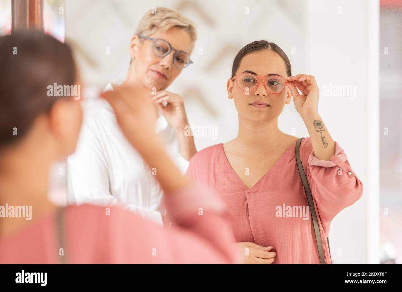 Lunettes, achat et contrôle miroir d'une femme et d'un assistant de magasin dans une clinique oculaire ou magasin de détail. Soin de la lentille, test visuel et achat de jeunes clients Banque D'Images