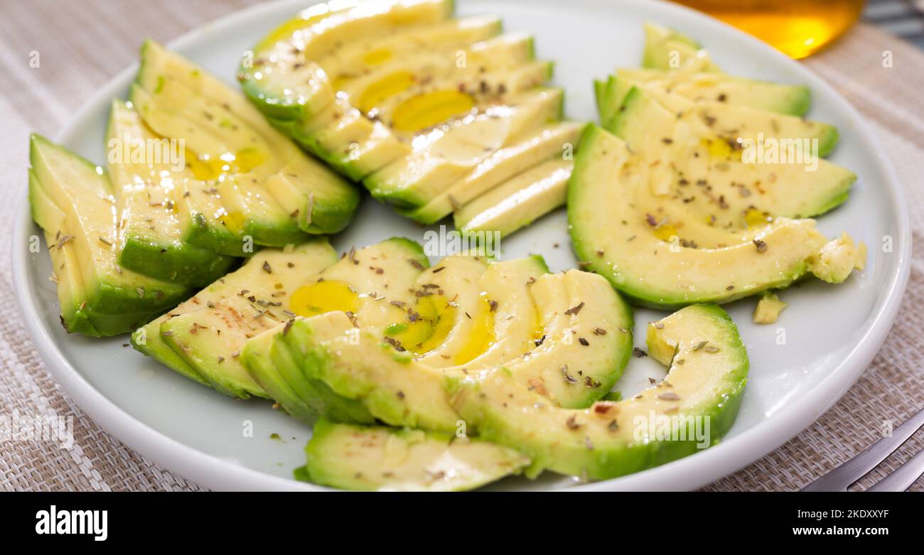 pulpe d'avocat mûre coupée en morceaux saupoudrée de jus de citron sur une assiette Banque D'Images