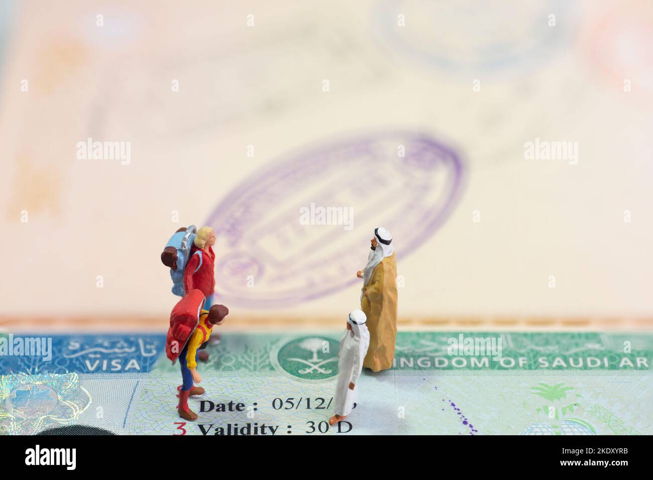 Concept de jouet miniature de deux Arabes accueillant des invités étrangers avec visa d'Arabie Saoudite comme arrière-plan. Banque D'Images